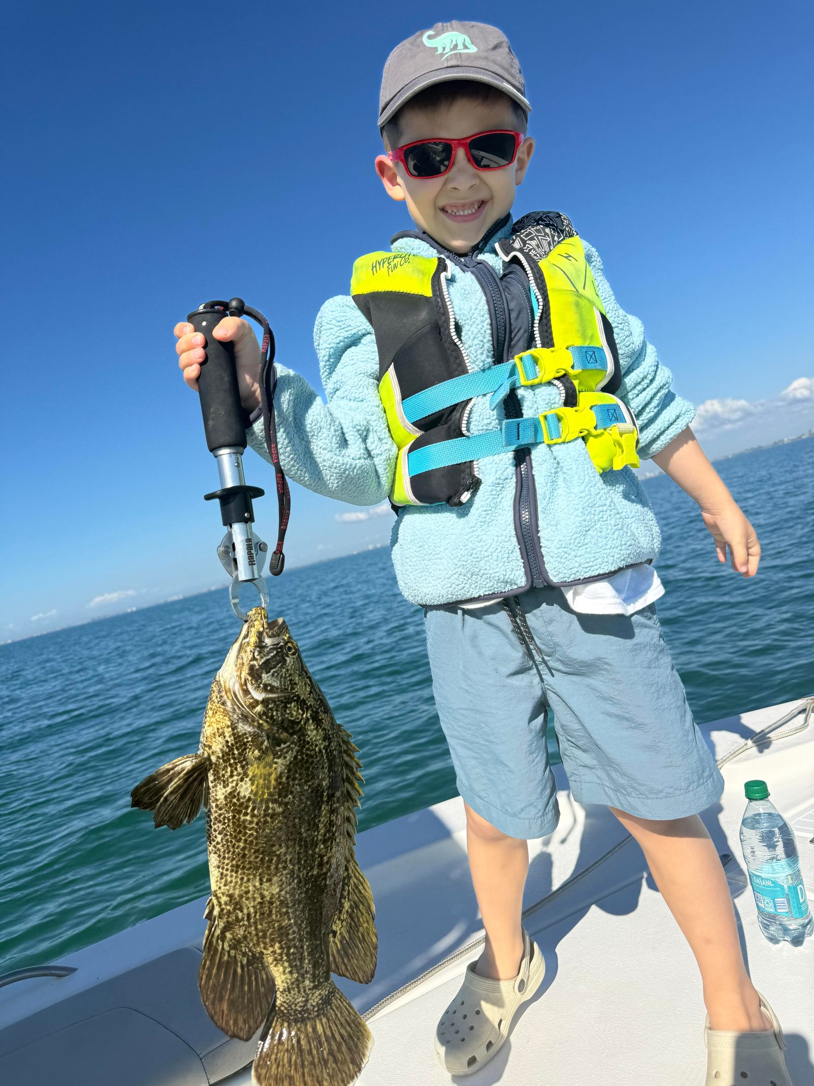 Family holding a fish at the boat on a Sarasota charter