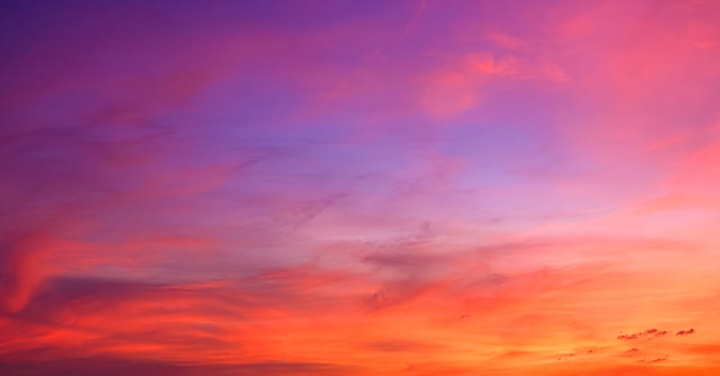 Layered orange, pink and violet cloud at sunset filling the whole frame, no horizon in view